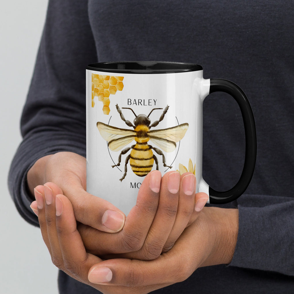 Barley Moon Botanicals 15oz ceramic mug with bee and honeycomb design held in hands, featuring a black rim and handle.