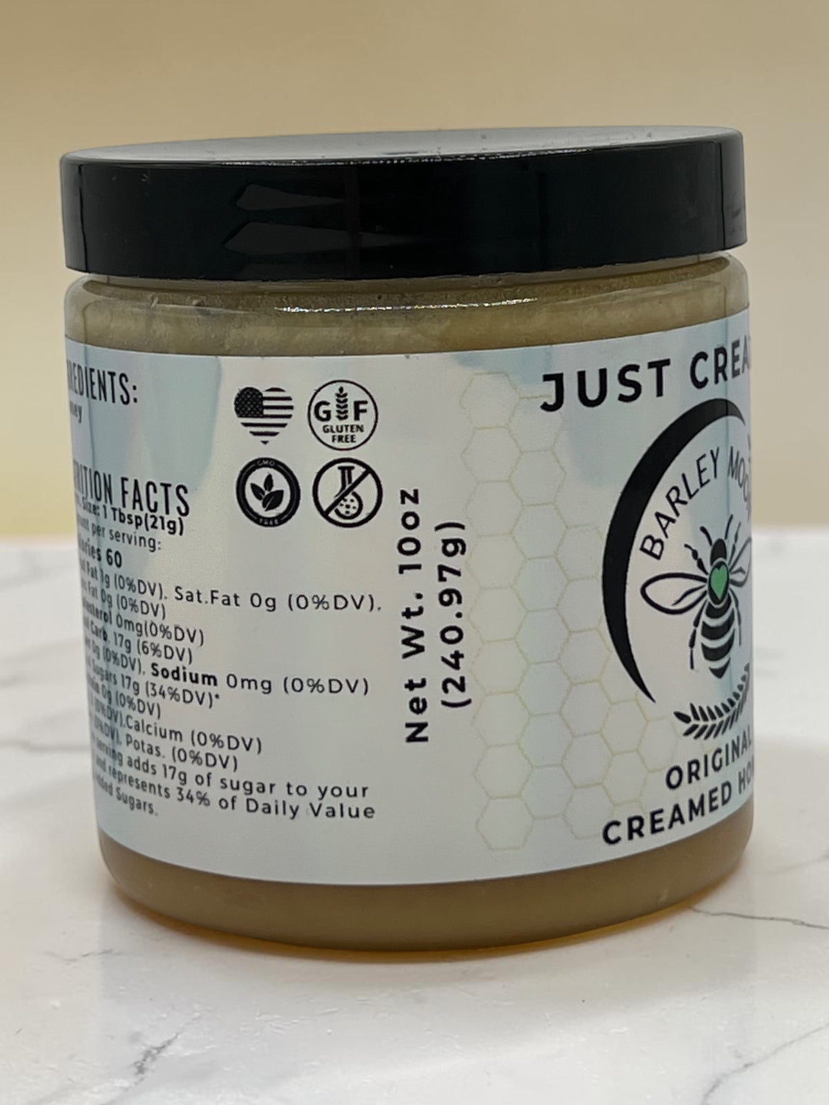 Barley Moon Botanicals Just Creamy original creamed honey in a 10oz glass jar with a black lid on a white surface.