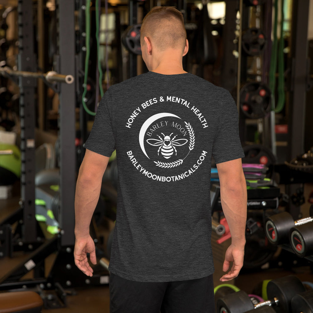 Man wearing a dark grey Barley Moon Botanicals t-shirt with a white bee and crescent moon logo on the back