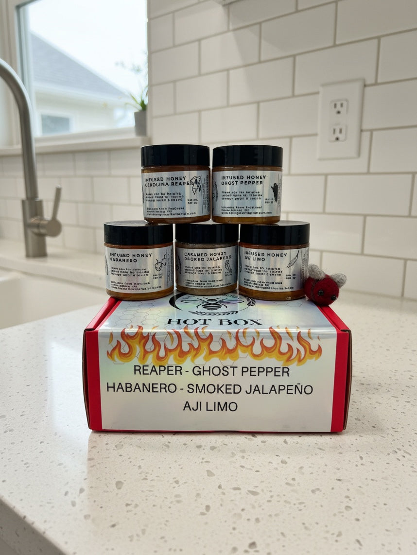 Barley Moon Botanicals Hot Box Honey Flight featuring five jars of spicy infused honey in a red gift box with a felt bee