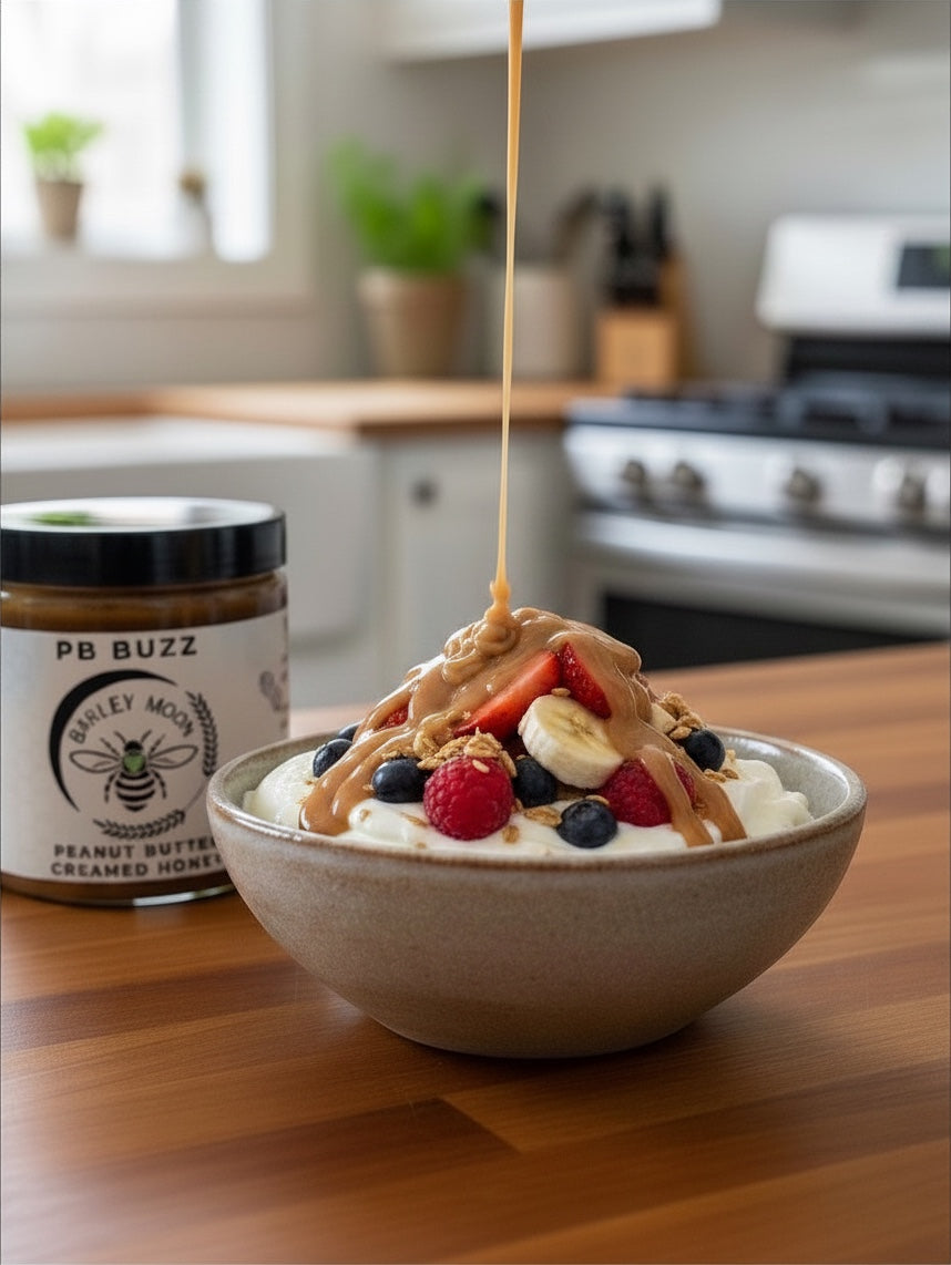 Barley Moon Botanicals PB Buzz peanut butter creamed honey drizzled over a bowl of yogurt with fresh berries and granola