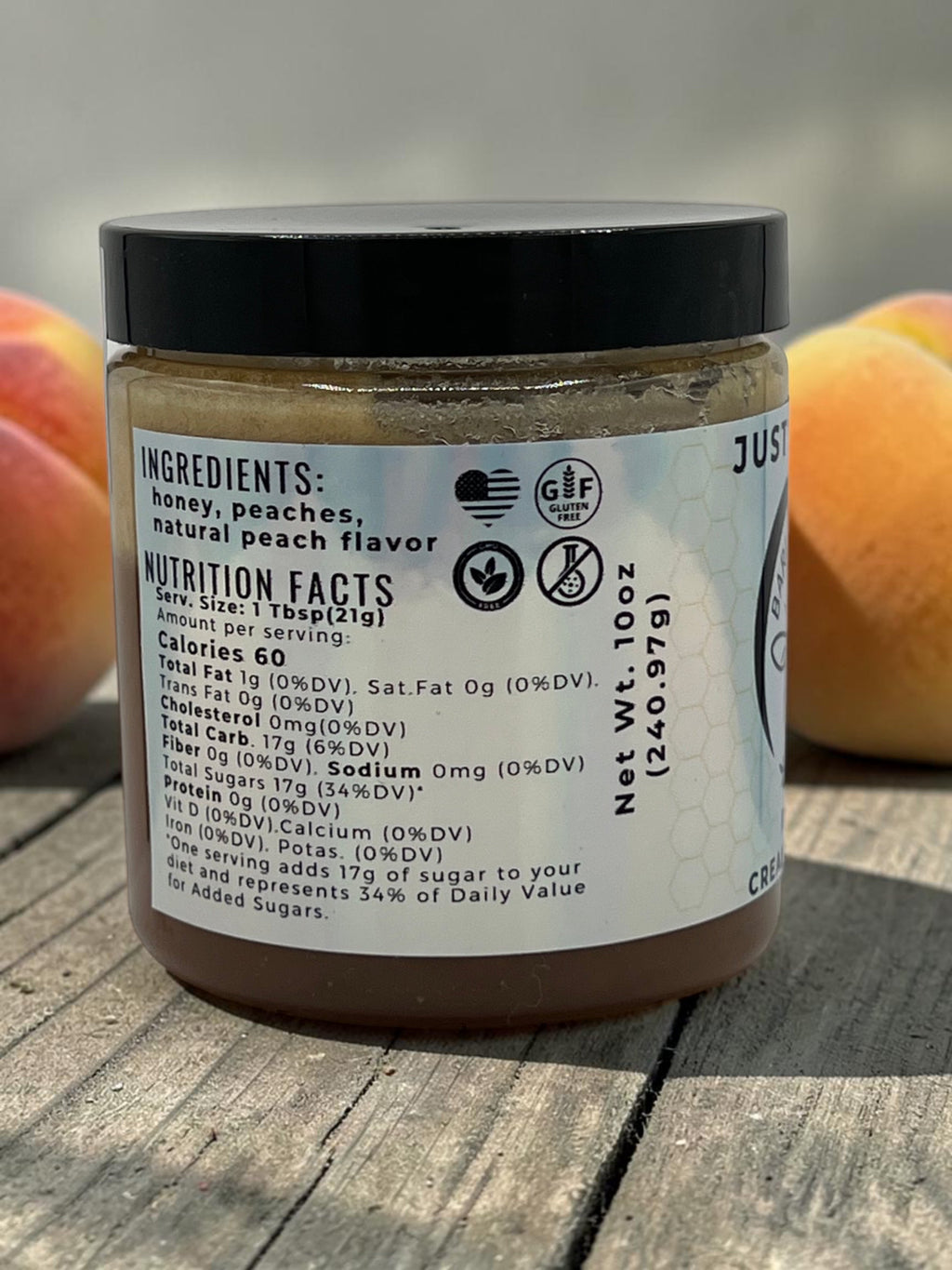 Barley Moon Botanicals Just Peachy creamed honey jar showing nutrition facts label on a rustic wooden surface