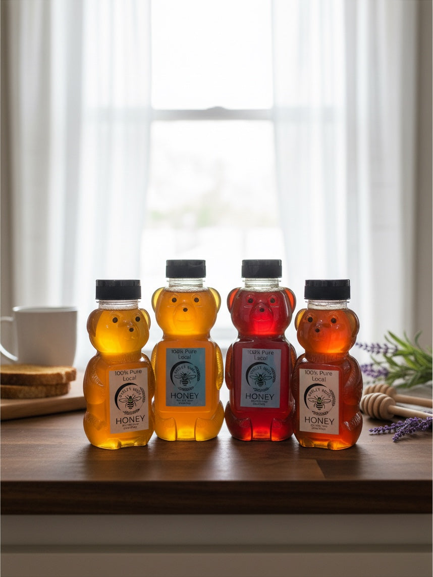 Barley Moon Botanicals raw local honey in four bear-shaped bottles of varying golden and amber hues on a wooden table.