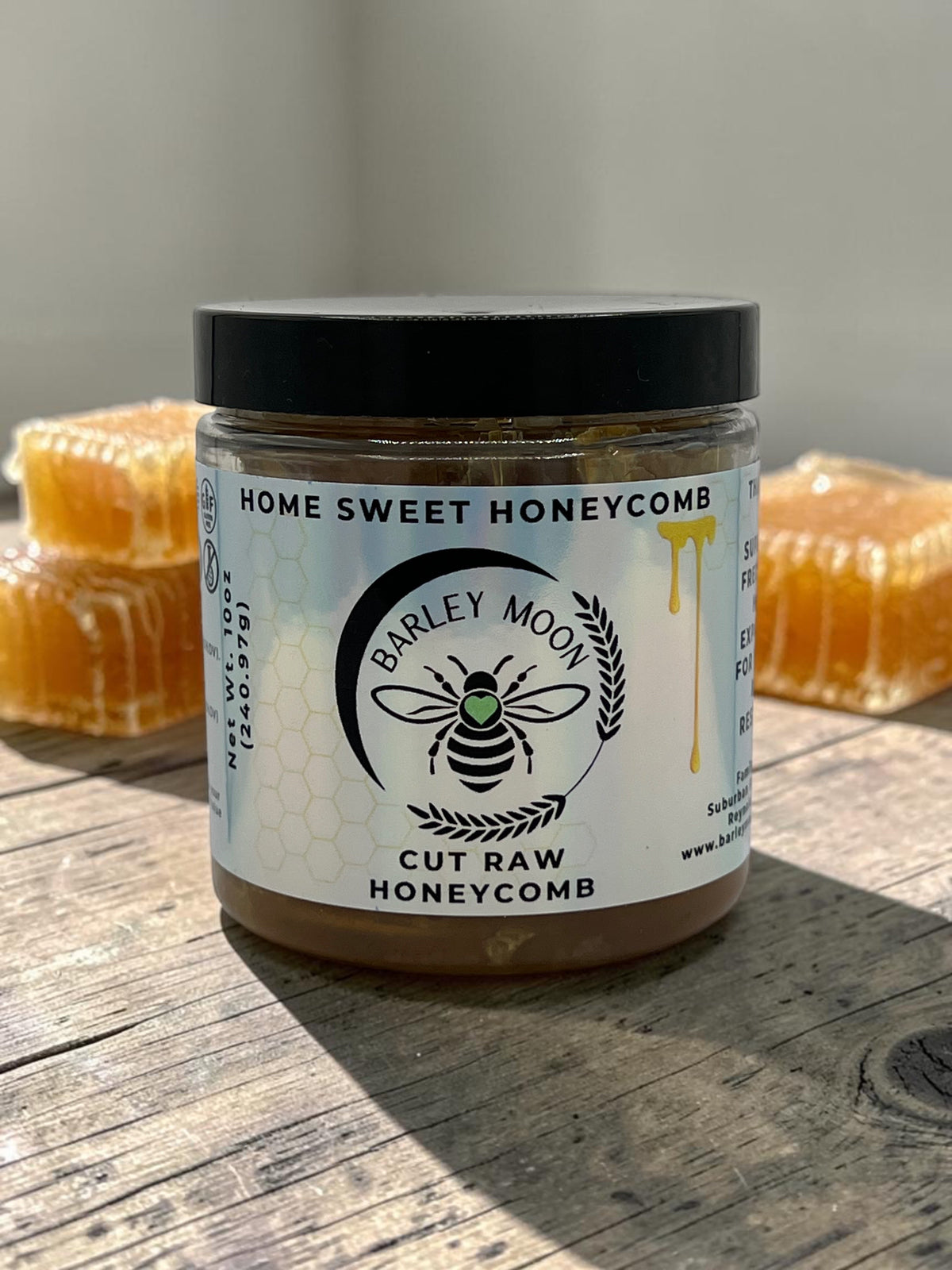Barley Moon Botanicals Home Sweet Honeycomb jar with raw honeycomb chunks on a rustic wooden surface
